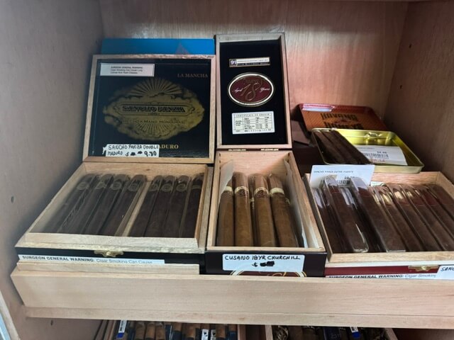 A photo of the inside of a humidor with Sancho Panza Double Madoro Cusando 18yr Churchill and Havana Honey cigars in boxes for sale in Pagosa Springs Colorado.