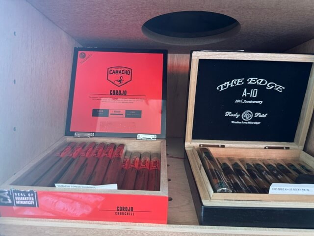 A red box of Corojo cigars and a black box of, Rocky Patel the edge A-10 Cigars for sale in a humidor in Pagosa Springs Colorado,