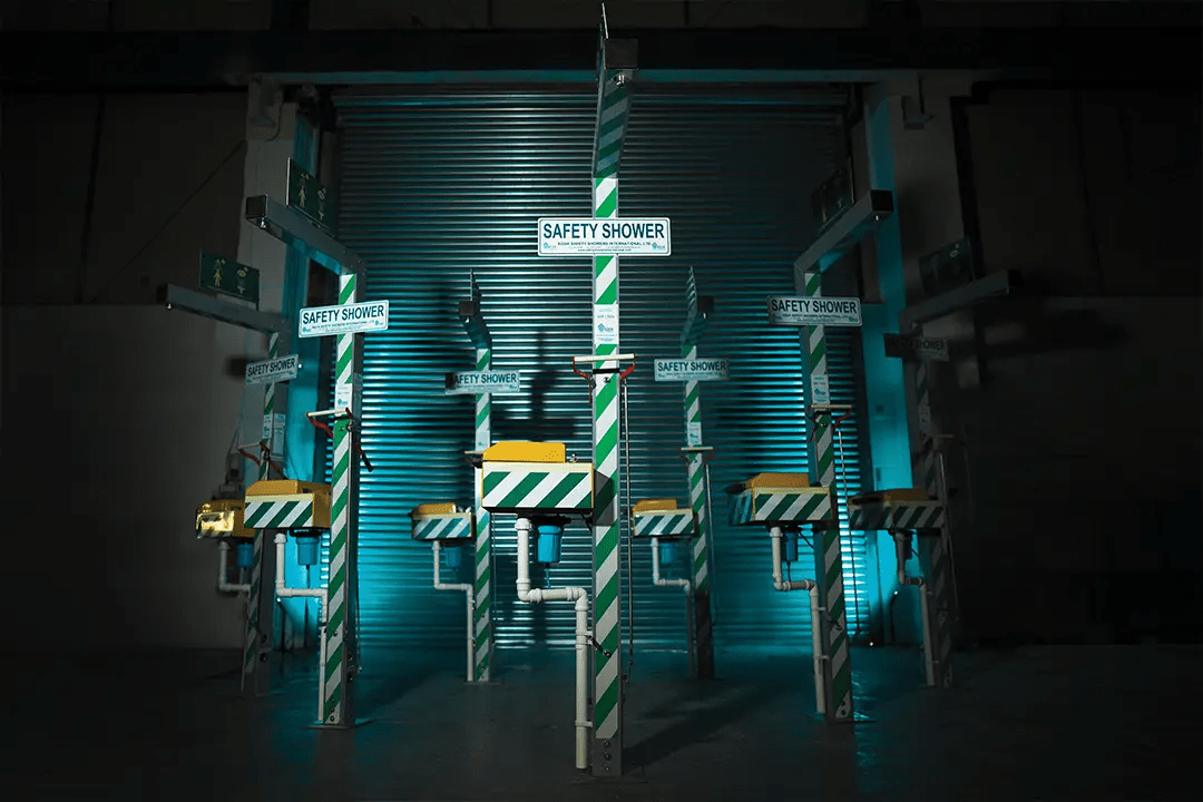 Row of Aqua Safety Showers industrial emergency units under dramatic lighting.