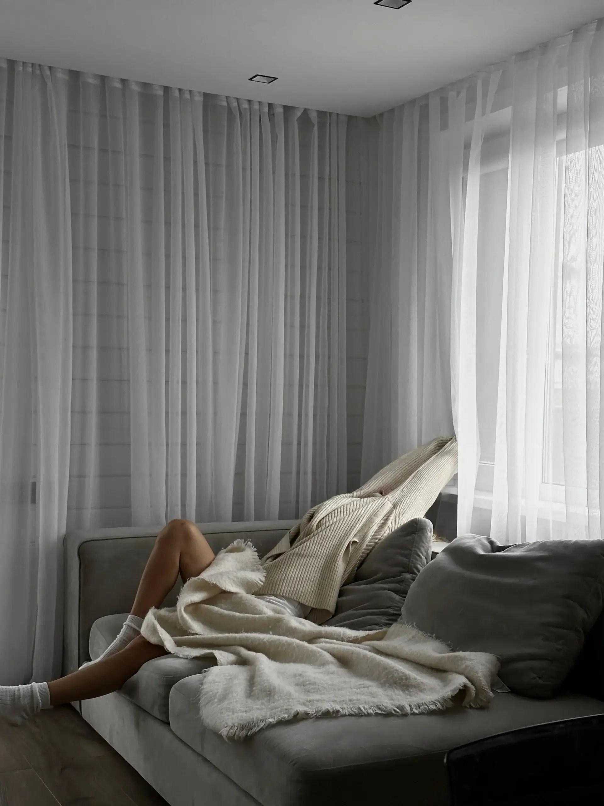 Person resting on a couch under a blanket, representing the importance of adapting habits to energy levels and practicing self-compassion with ADHD.