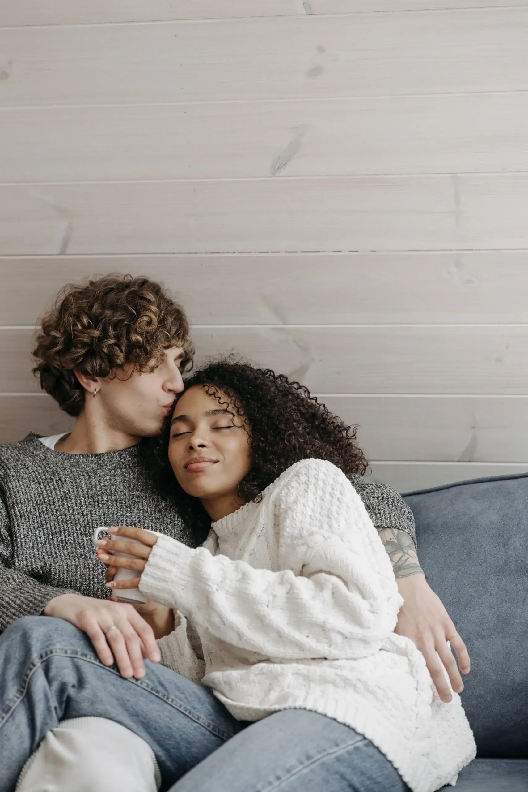 Couple embracing on a couch, illustrating emotional safety, connection, and relationship growth through healthy communication.