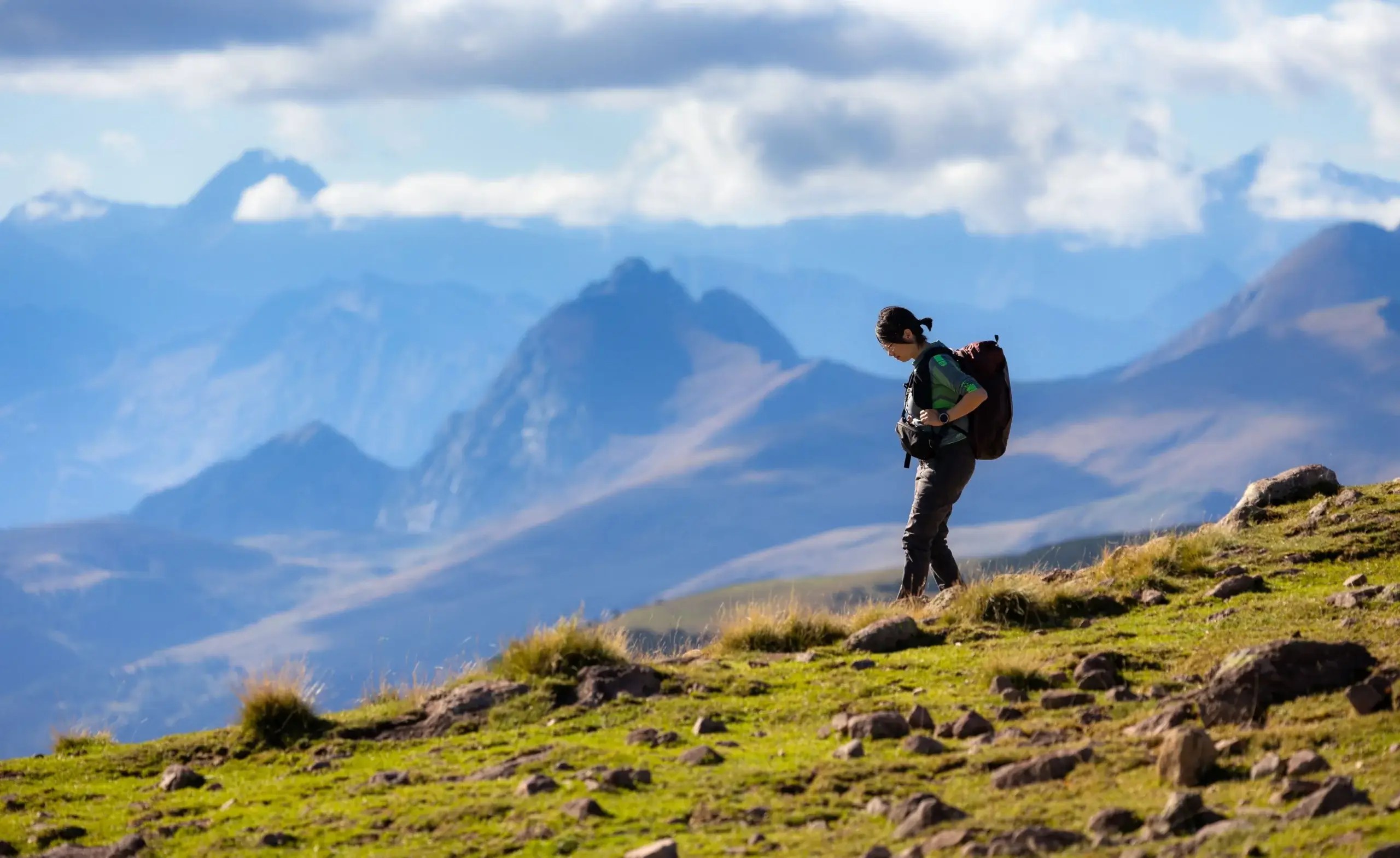 Person hiking through a mountain landscape, symbolizing emotional resilience, hope, and moving forward after disappointment.