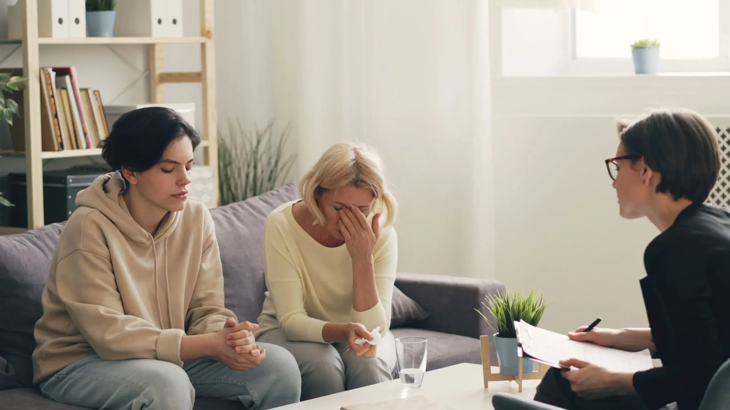 Adult family members meeting with a therapist to explore relationship patterns, communication, and emotional healing during a family therapy session.