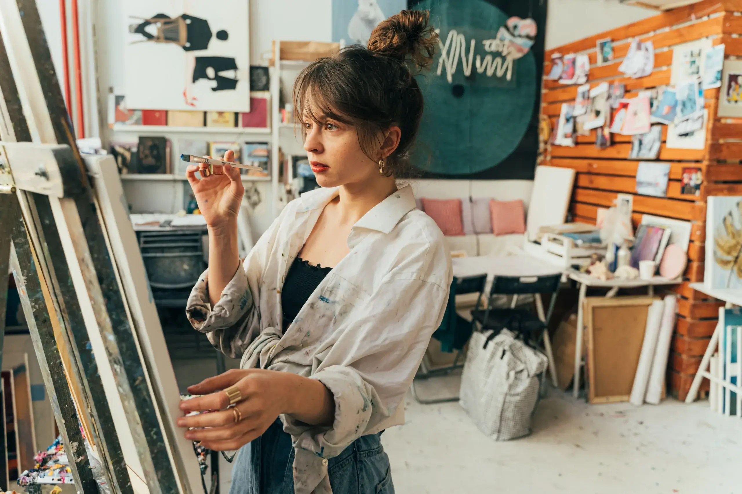 Person painting on a canvas in an art studio, representing expressive arts therapy and creative healing for emotional wellbeing.