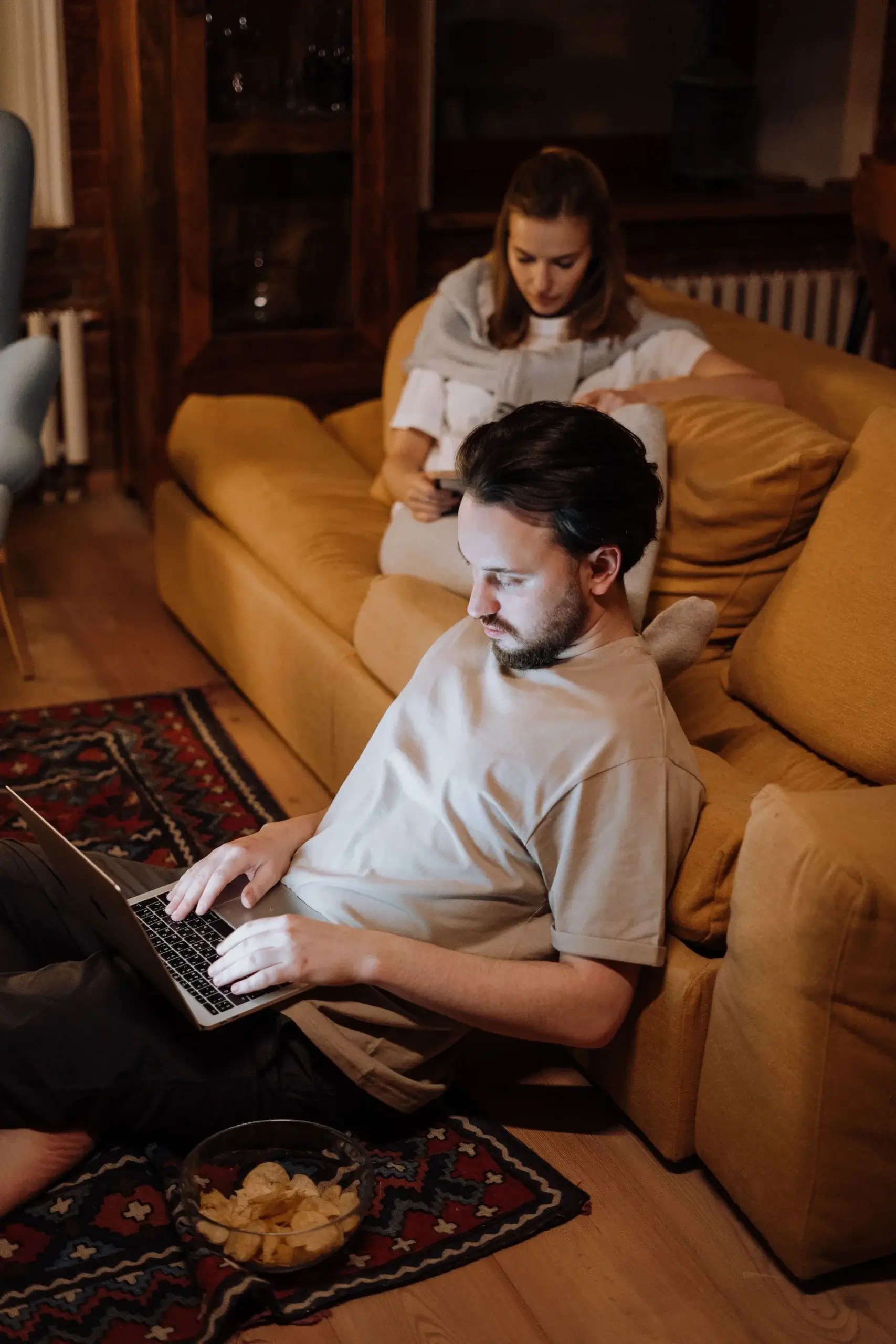 Couple sitting apart in the same room, illustrating the importance of healthy boundaries, emotional space, and secure attachment in relationships.