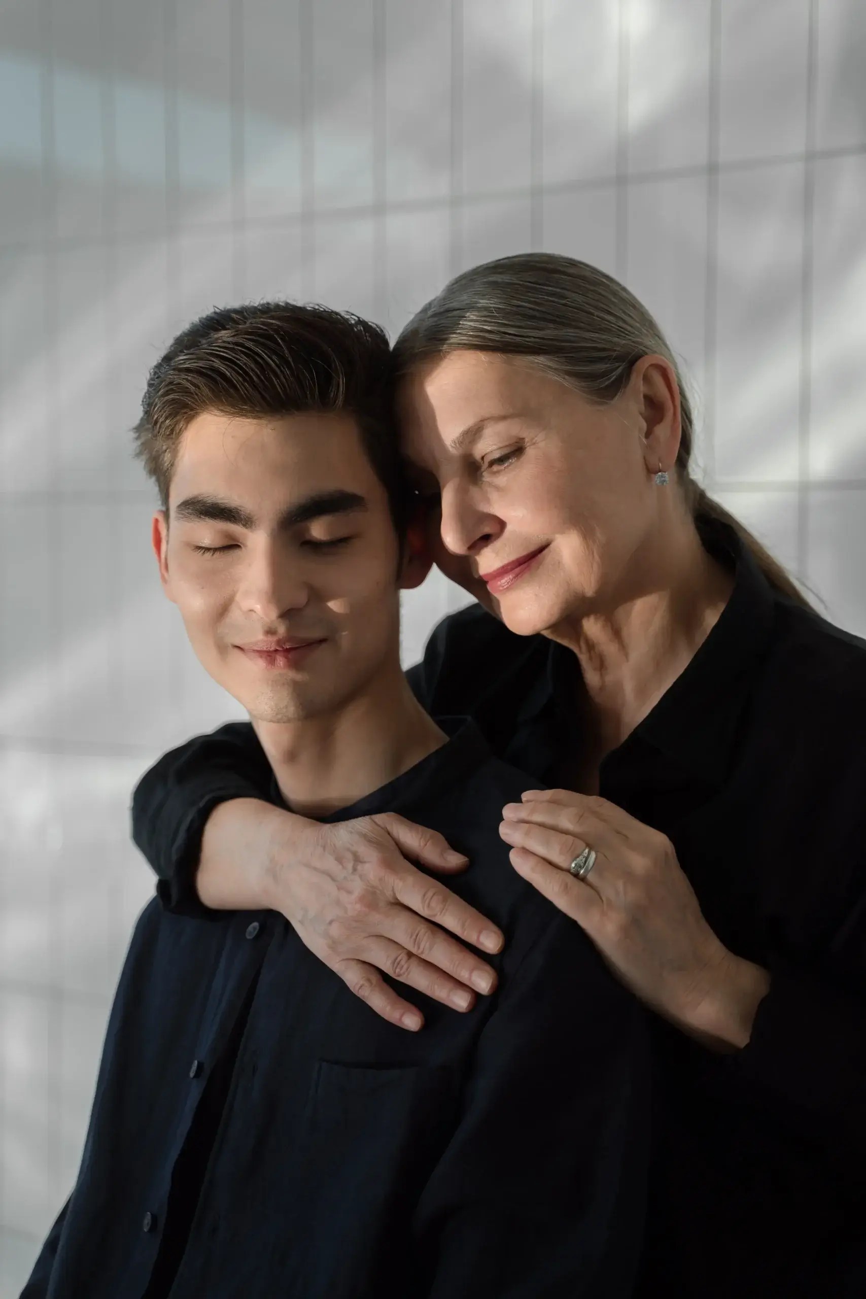 Parent embracing their adult child, illustrating how loving families can still experience attachment wounds and developmental trauma.