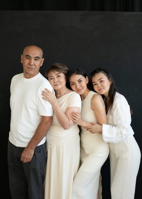 Multigenerational Asian family standing closely together for a portrait.