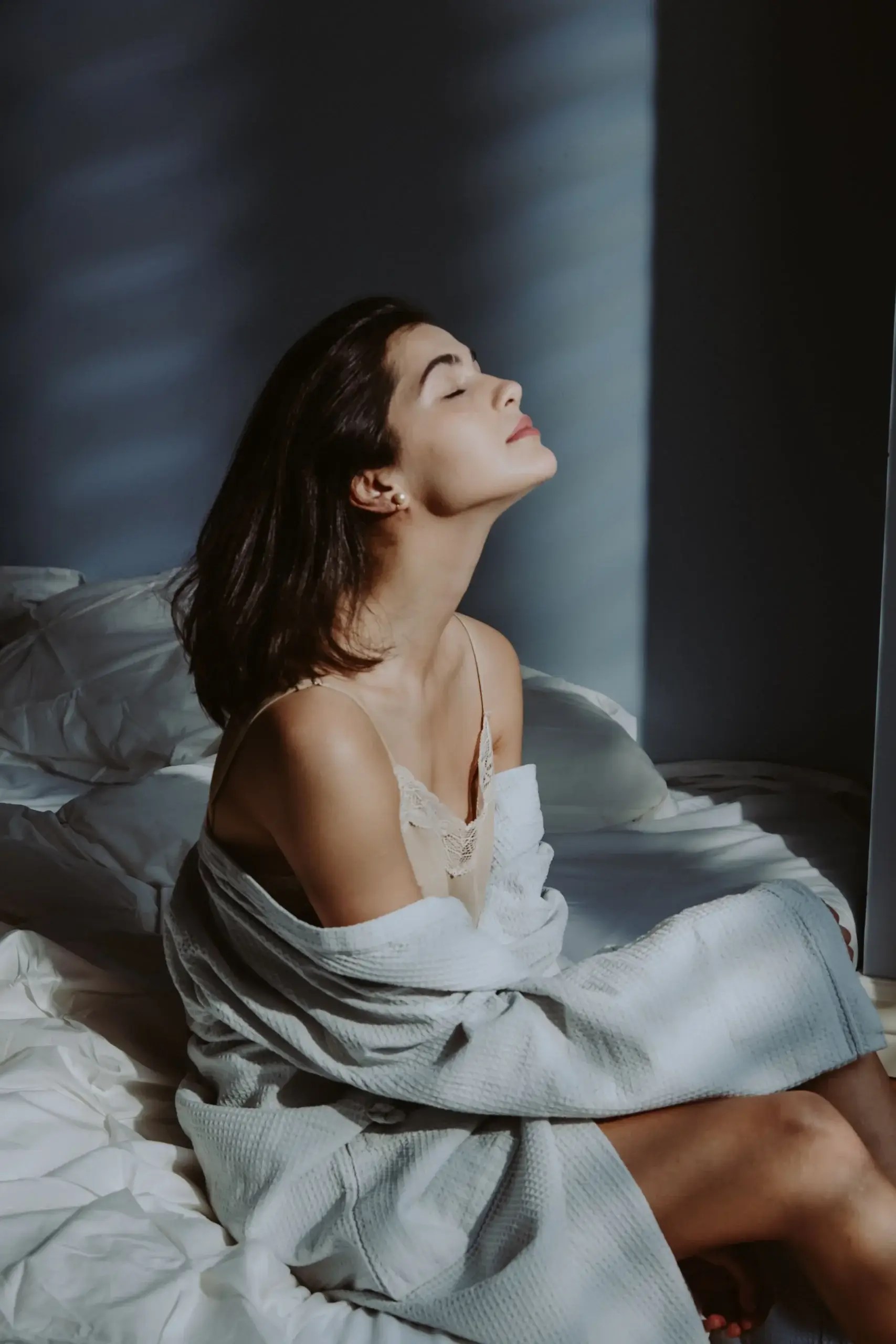 Woman relaxing and reconnecting with her body in a quiet bedroom