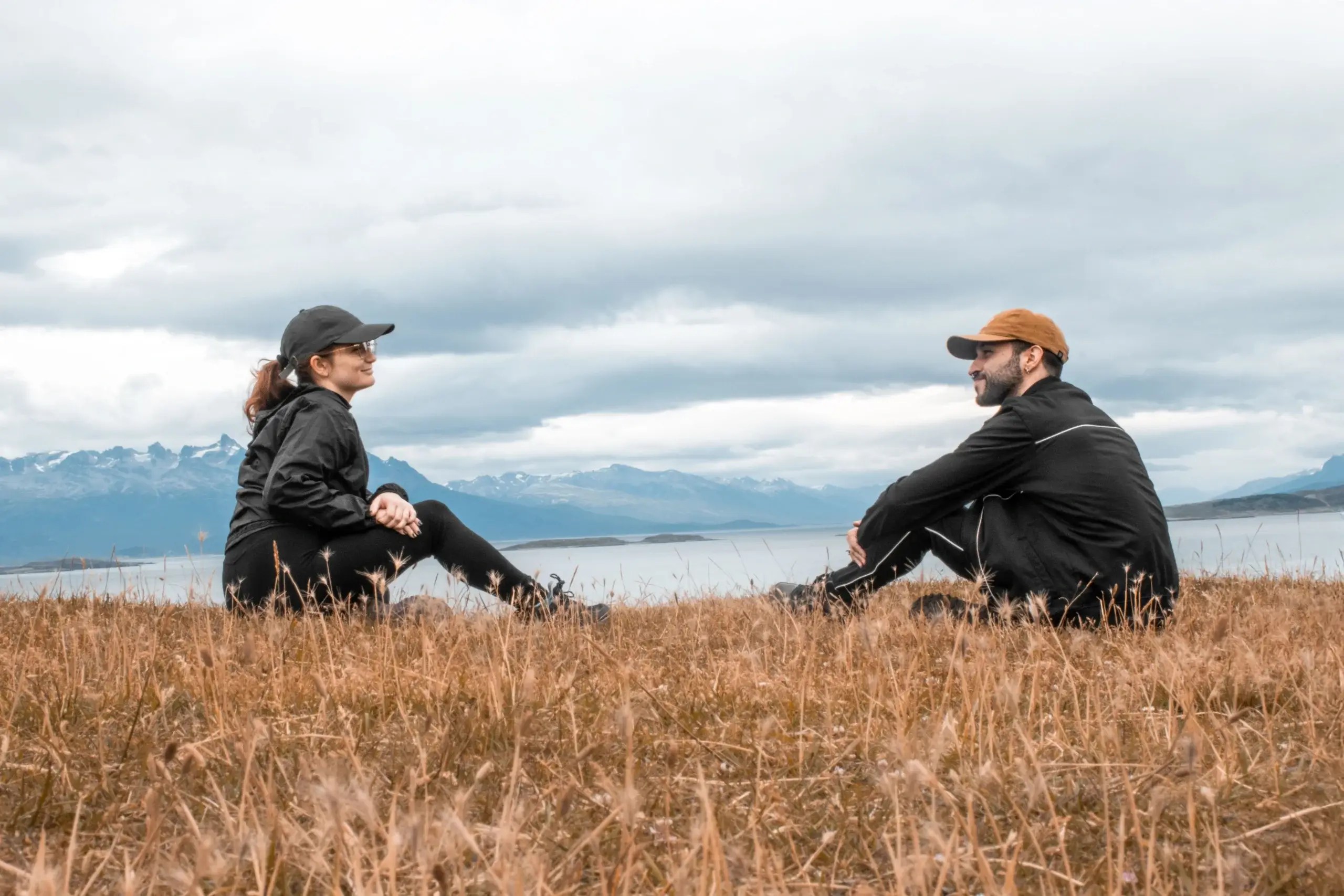 Couple sitting across from each other outdoors, representing communication, emotional connection, and understanding relationship patterns in Emotionally Focused Therapy.