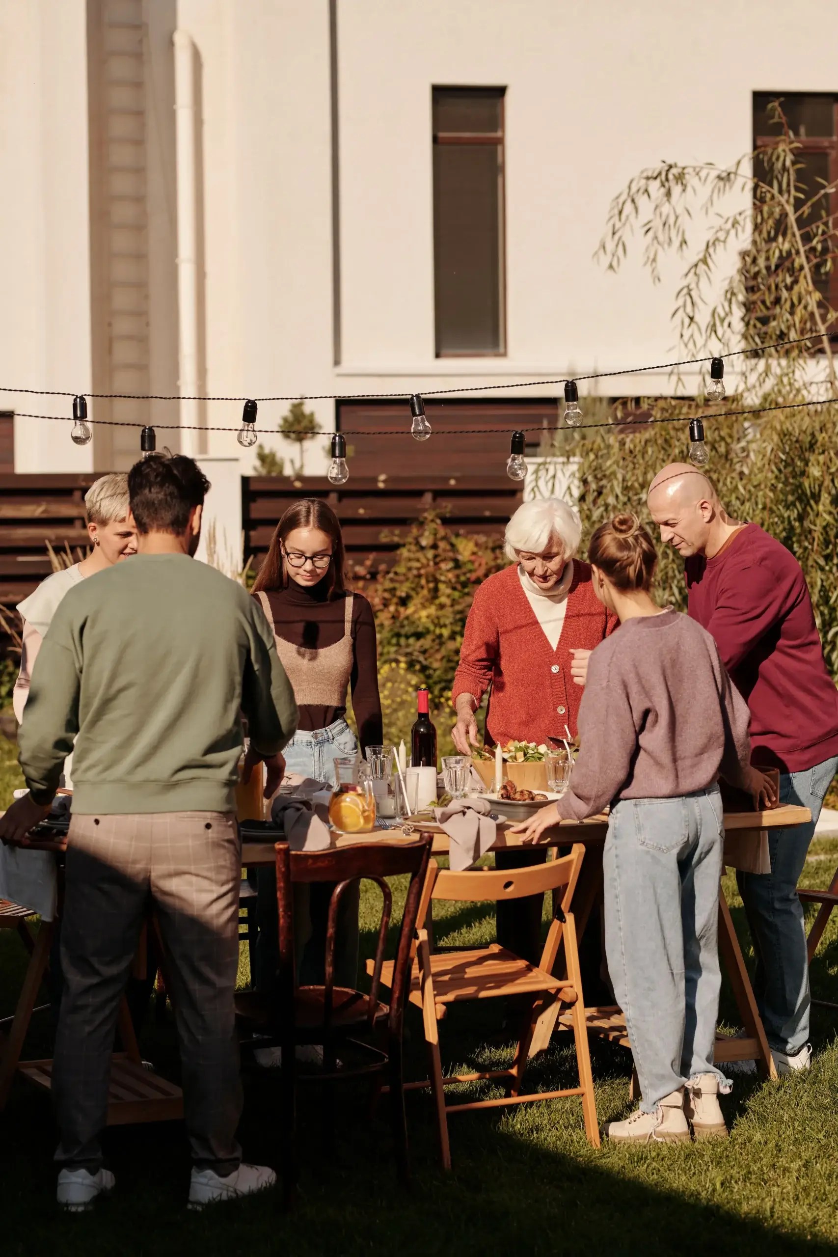 Family members gathering around a table outdoors