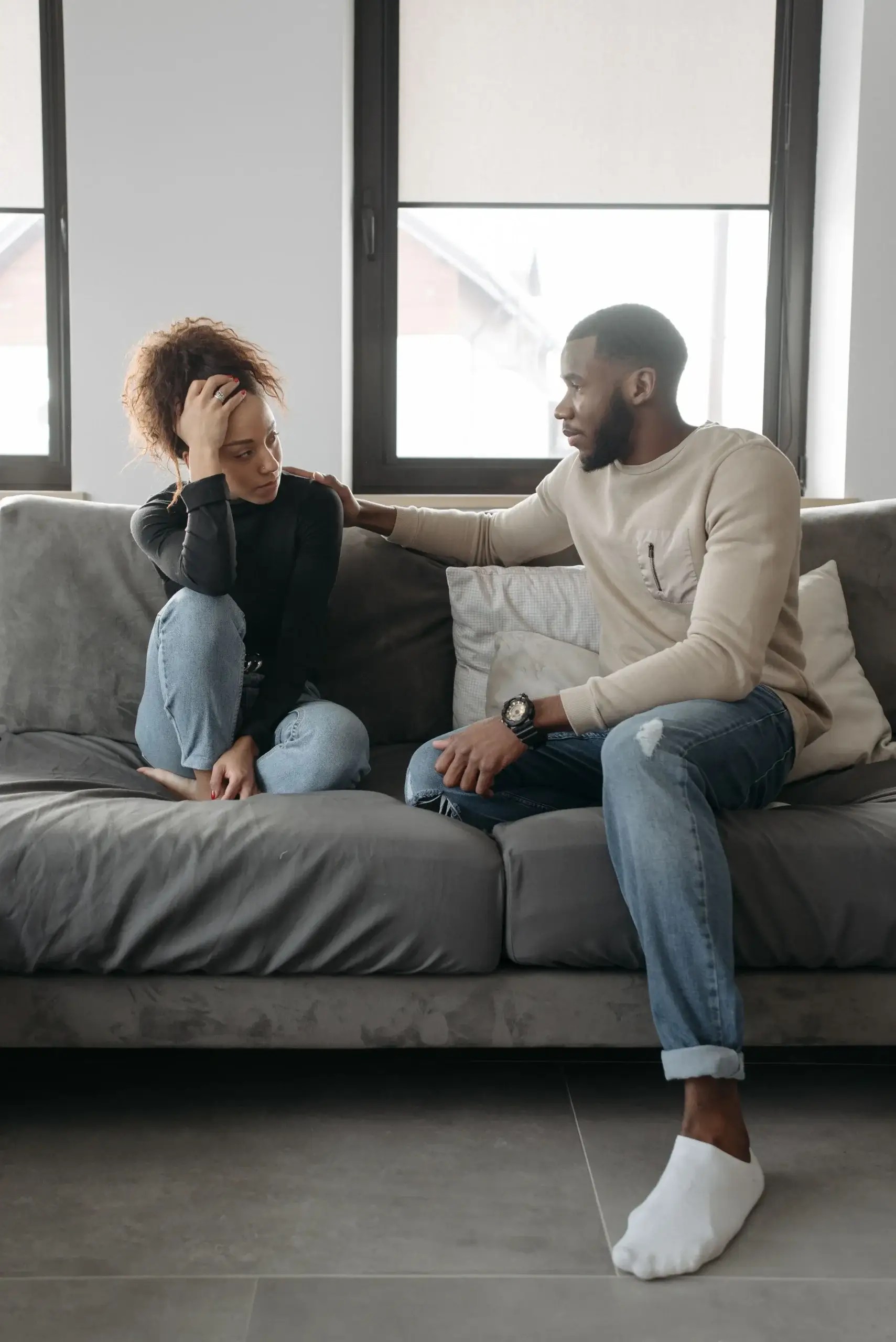 Couple sitting apart on a sofa during a difficult relationship conversation
