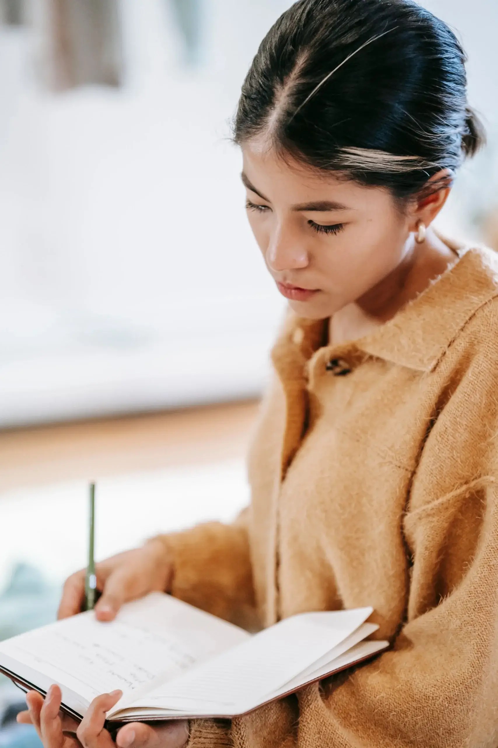 Woman journaling while reflecting on her emotional response