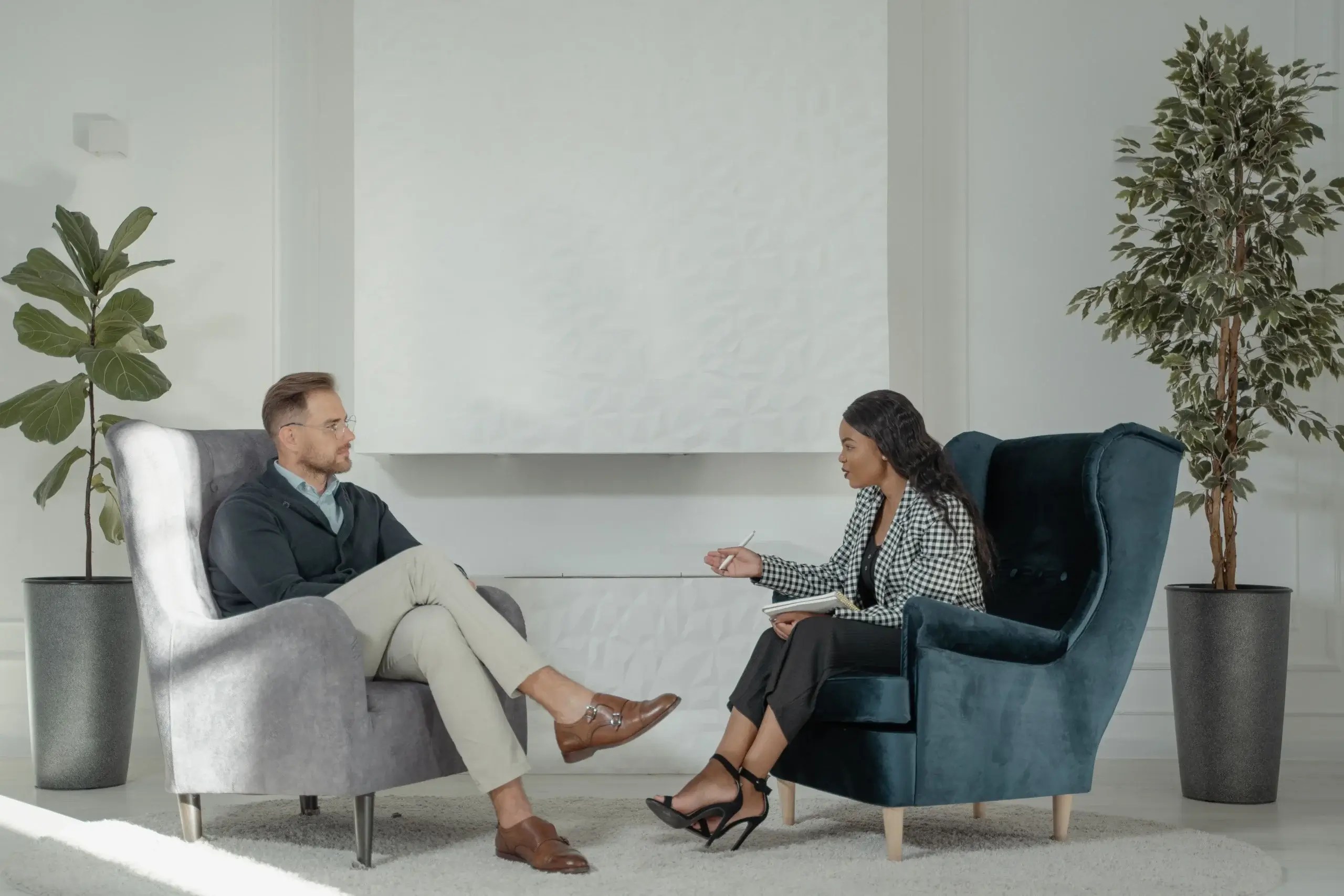 Professional woman sitting on a sofa in a bright, comfortable living space.