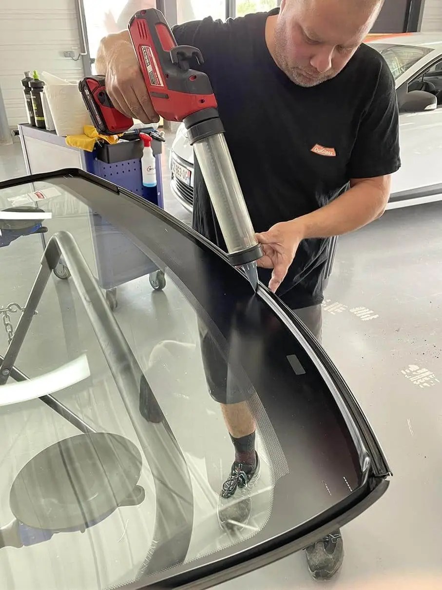 Photo de l'application de la résine étanche pour coller les pare-brises dans l'atelier de OuiGlass Anglet
