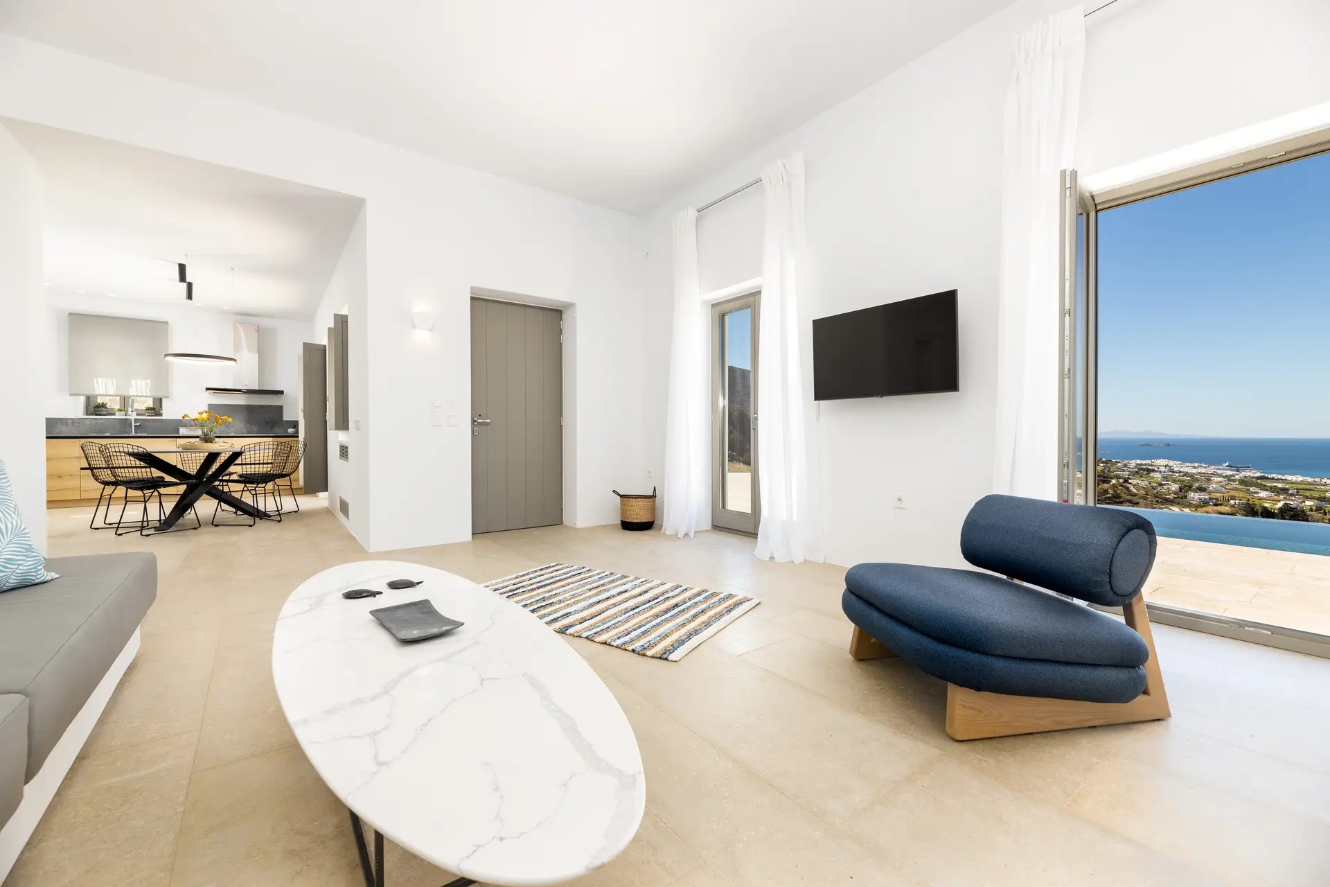 Contemporary living room with sea view and terrace access in Paros luxury villa rental.