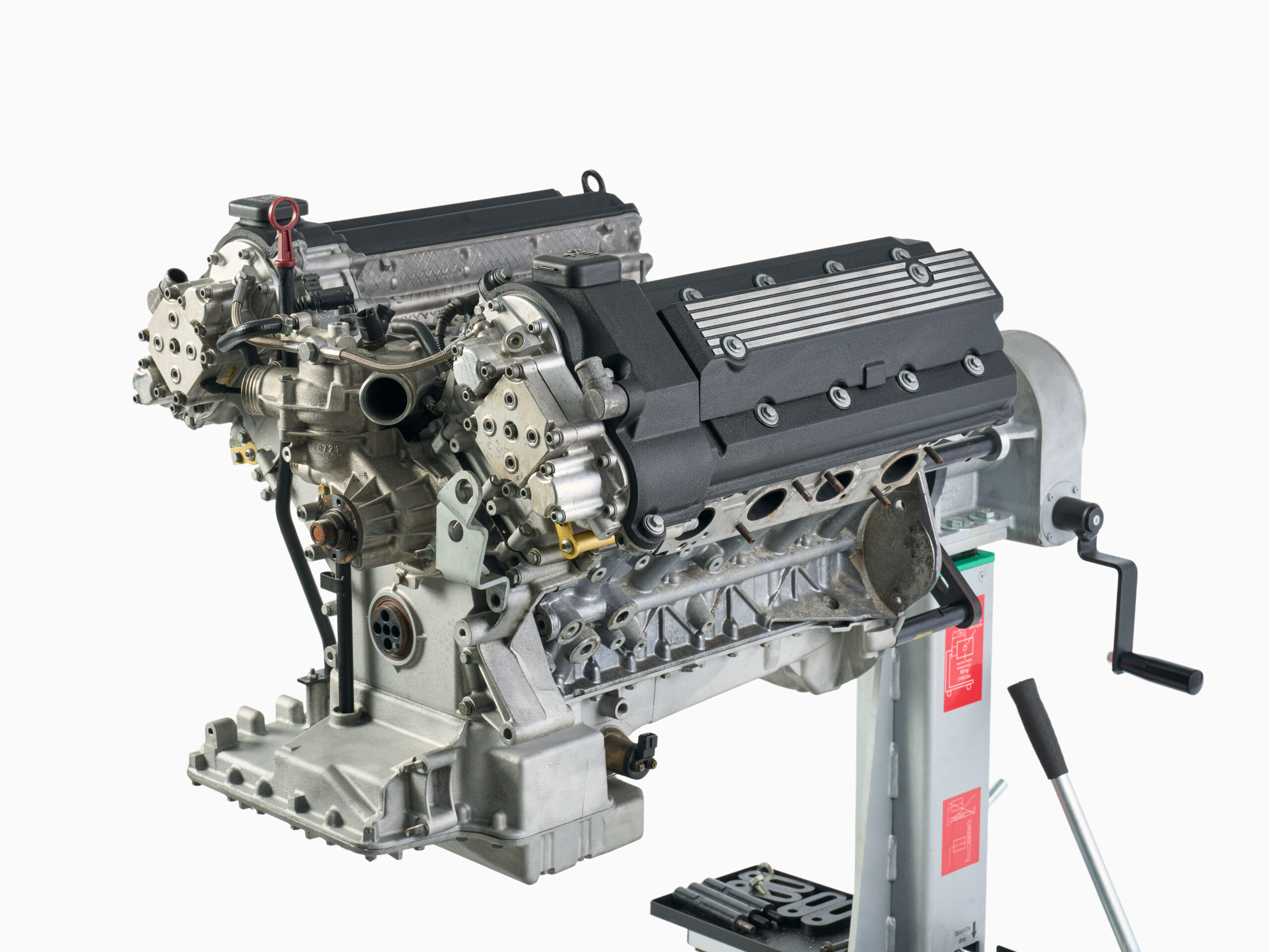 BMW S62 engine longblock on assembly stand with wrinkle black valve covers and bead-blasted aluminum components.