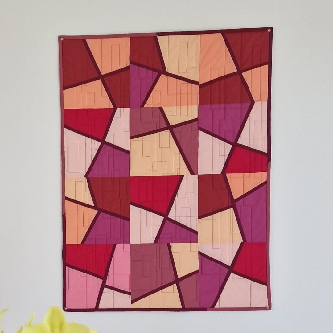 Panneau patchwork moderne abstrait aux tons rose, bordeaux et saumon, réalisé par Patchaka