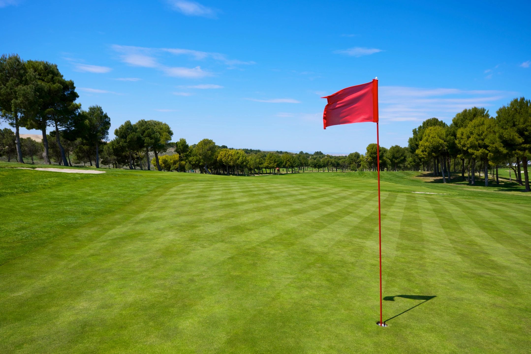 red golf flag on green waving in the wind