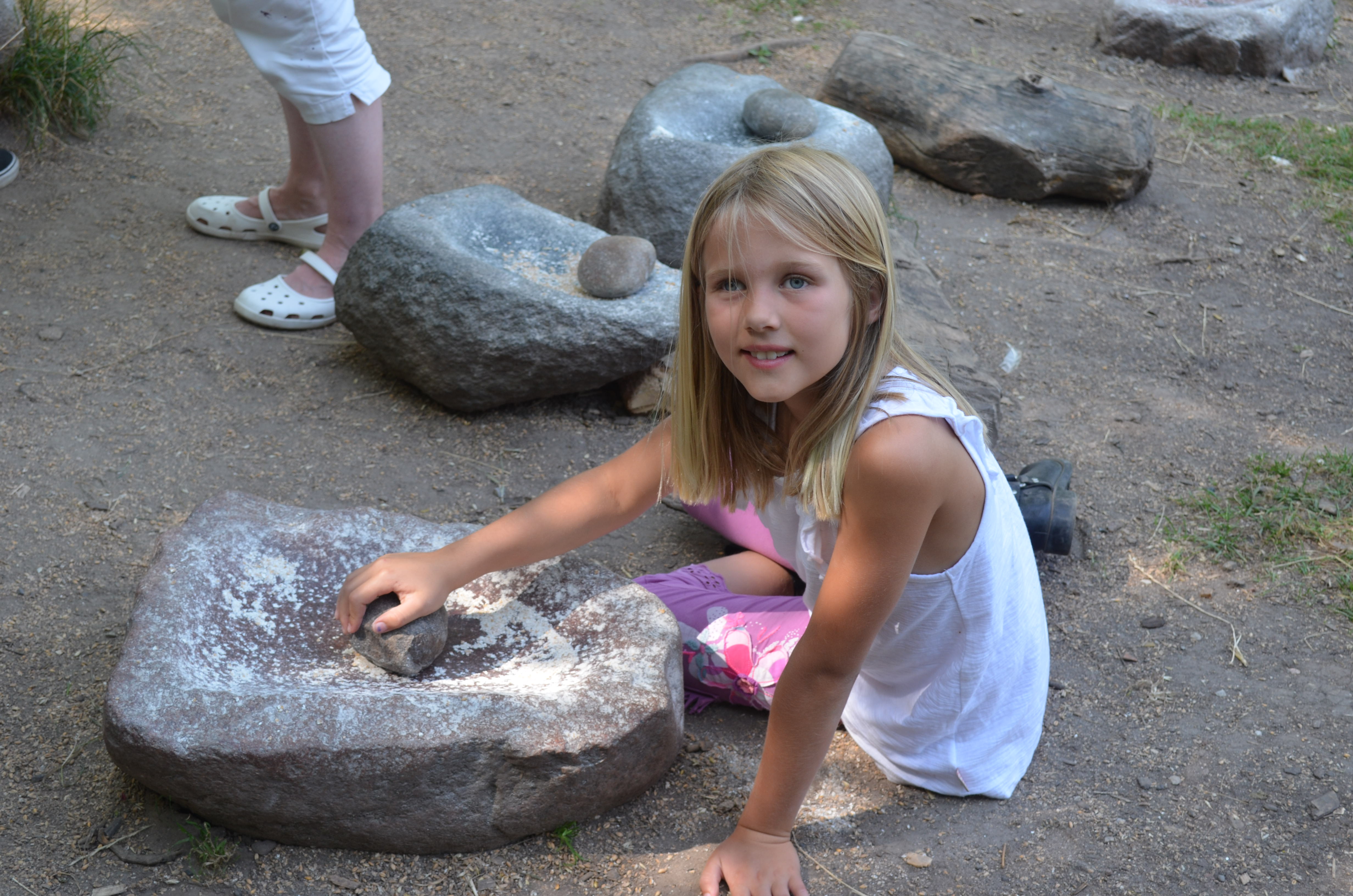 Grinding corn for cakes.