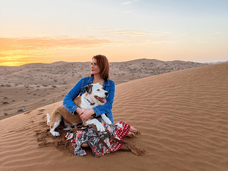Carmen and Marty sitting on a desert dune at sunset.