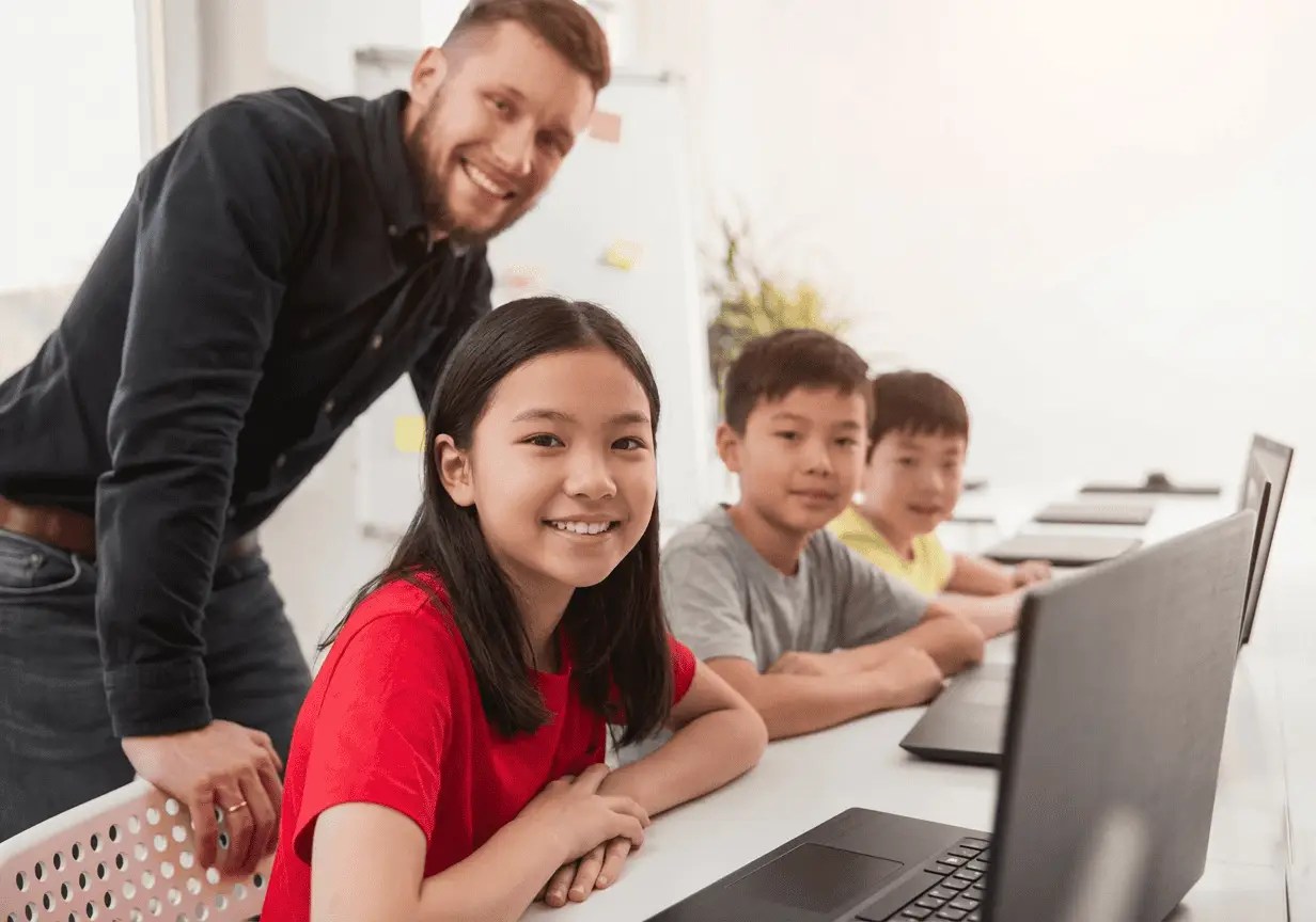 程式課堂中，老師指導學生使用電腦學習基礎程式設計