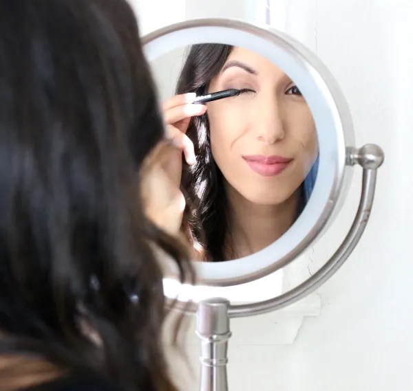 girl applying makeup at a mirror