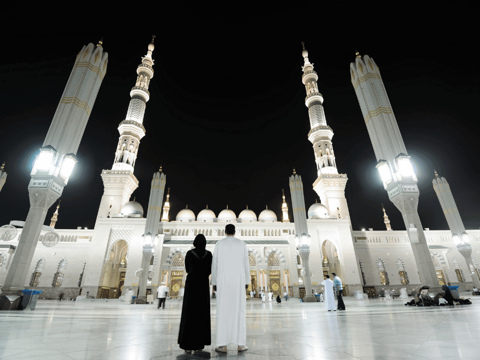Deux pèlerins de nuit devant le Masjid an-Nabawi à Médine lors d’une Omra depuis la Belgique