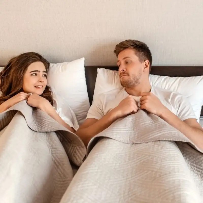 A couple in bed worried about intimacy causing an IC flare.