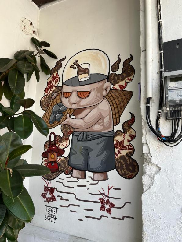 Graffitied Street Art Phuket Thailand of a man with coffee on the brain.