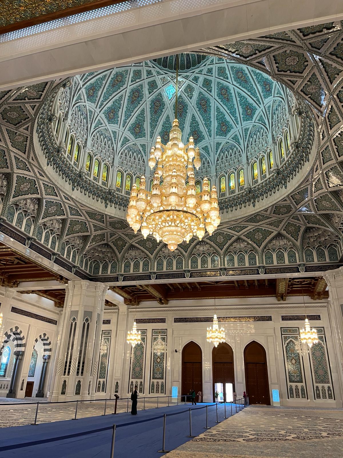 Chandelier and intricate paintings on the ceiling of the Sultan Qaboos Grand Mosque Muscat Oman