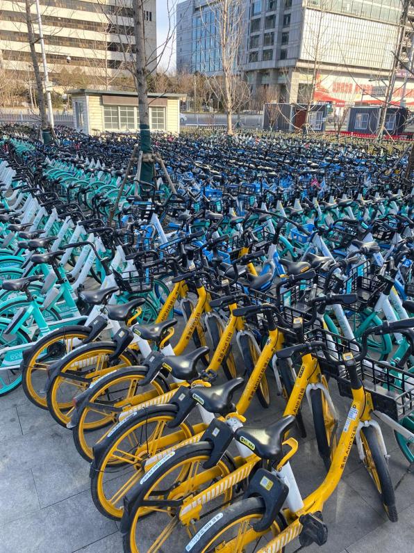 A massive amount of rental bikes near a subway station.