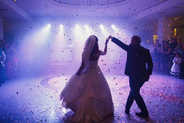 Happy beautiful newlyweds dancing in the restaurant
