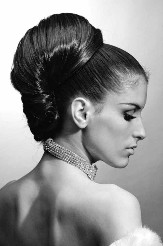 Graceful profile portrait of a woman with elegant hairstyle and necklace.