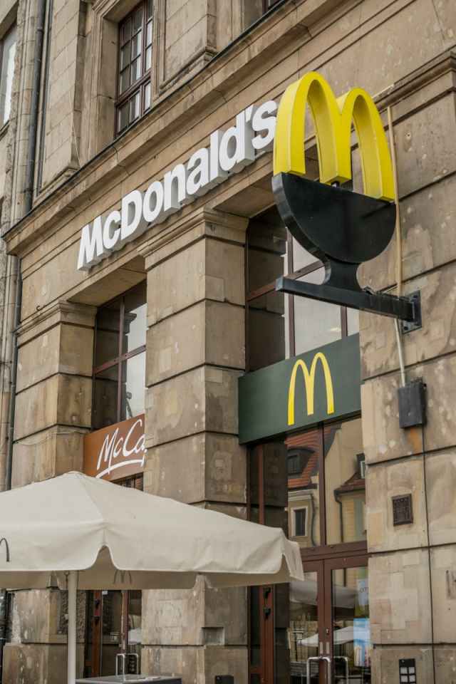 Street view of a McDonald's facade in Wrocław, Poland showcasing the iconic golden arches.