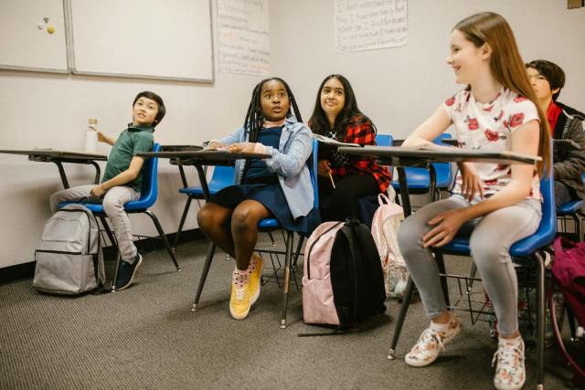 A diverse group of students attentively participating in a classroom setting.