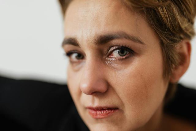 Close-up of a woman with tearful eyes, capturing deep emotions and sadness.