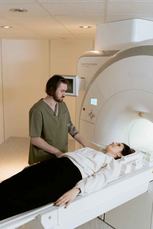 A healthcare worker assists a patient during an MRI scan in a clinical setting.