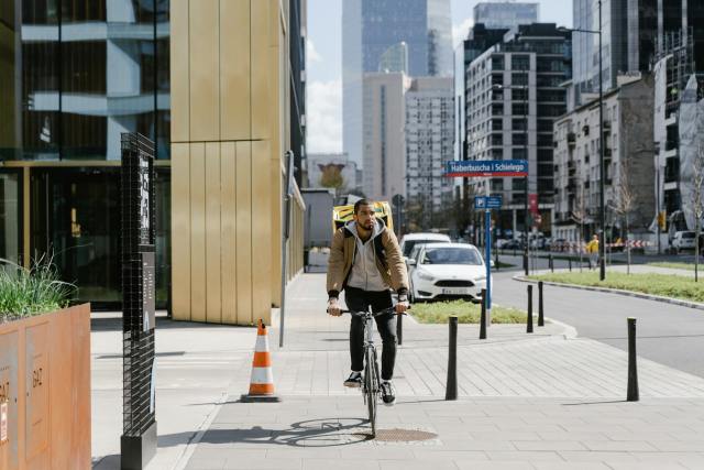 Cyclist with thermal bag delivering food in urban Warsaw, Poland.
