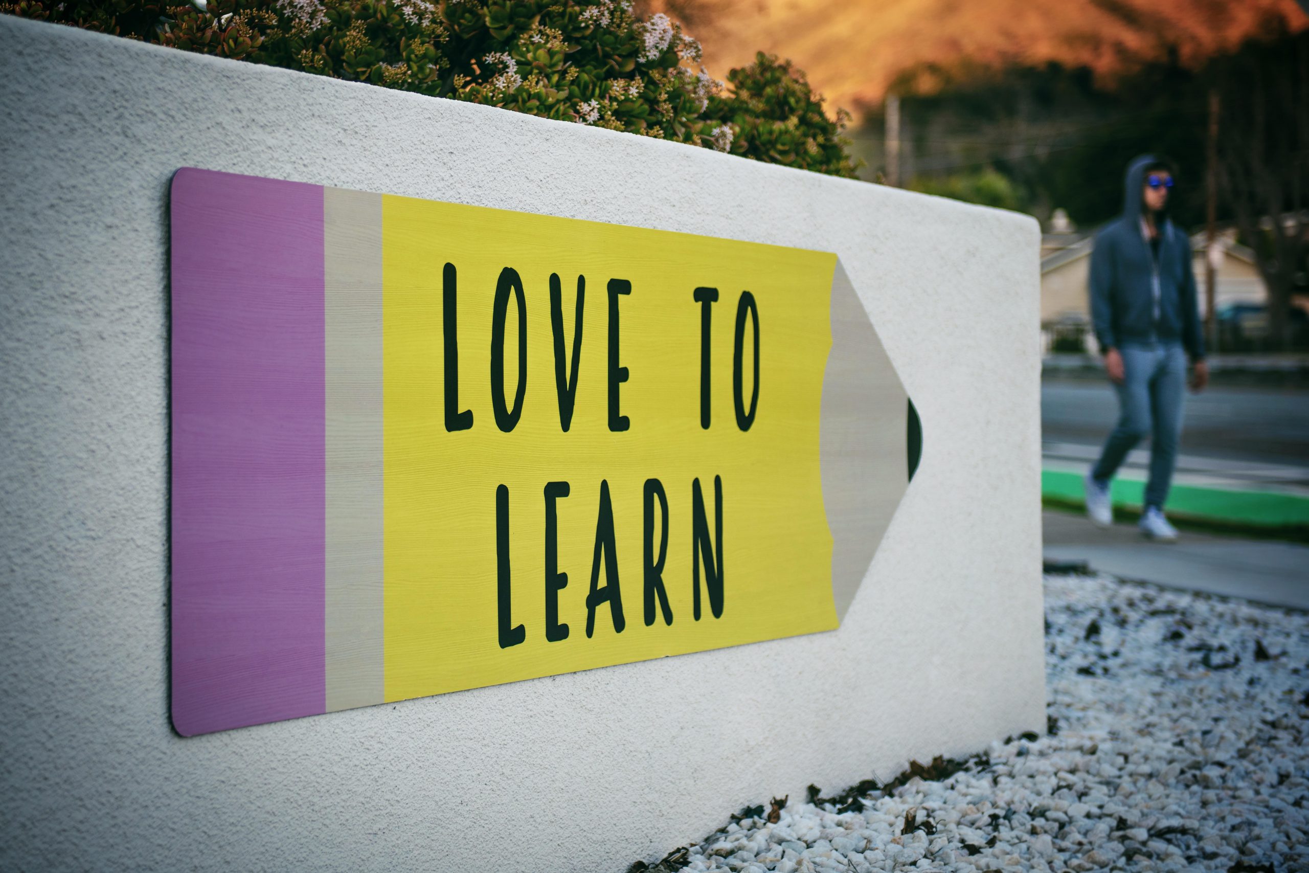 Eine große Tafel mit einem riesigen Bleistift, der mit "Love to Learn" beschriftet ist