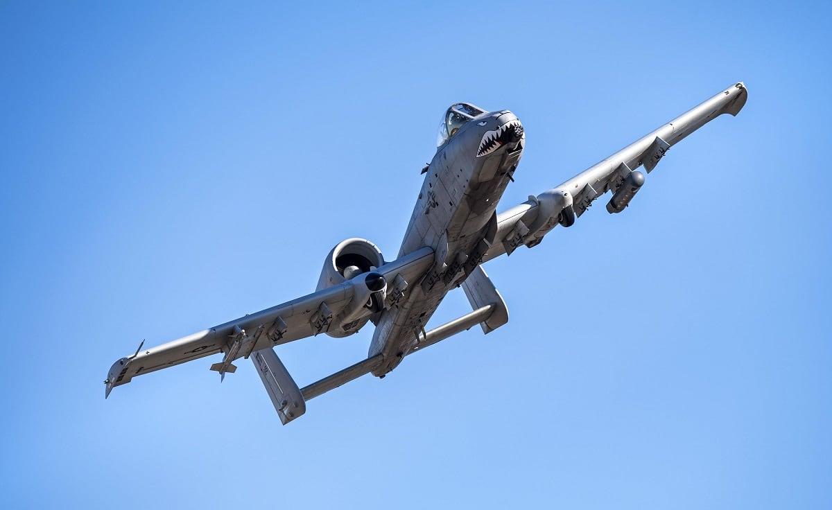 A-10 Thunderbolt II attack aircraft banking in flight against a clear blue sky