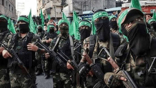 Masked soldiers in green camouflage and headbands lined up holding assault rifles