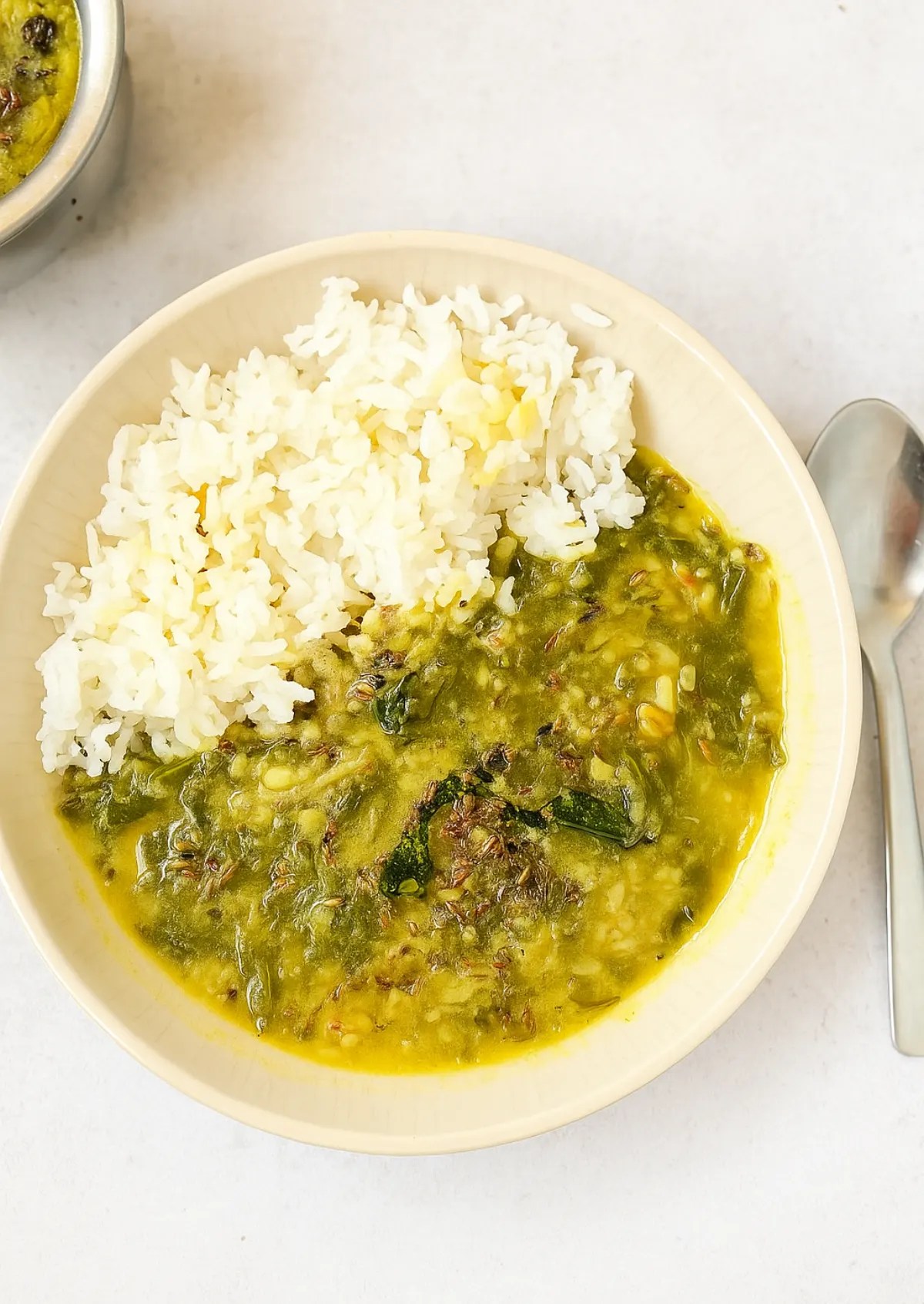 Palak dal served in a rustic bowl with bright green spinach-toor dal, ghee tempering, and a lemon wedge on the side