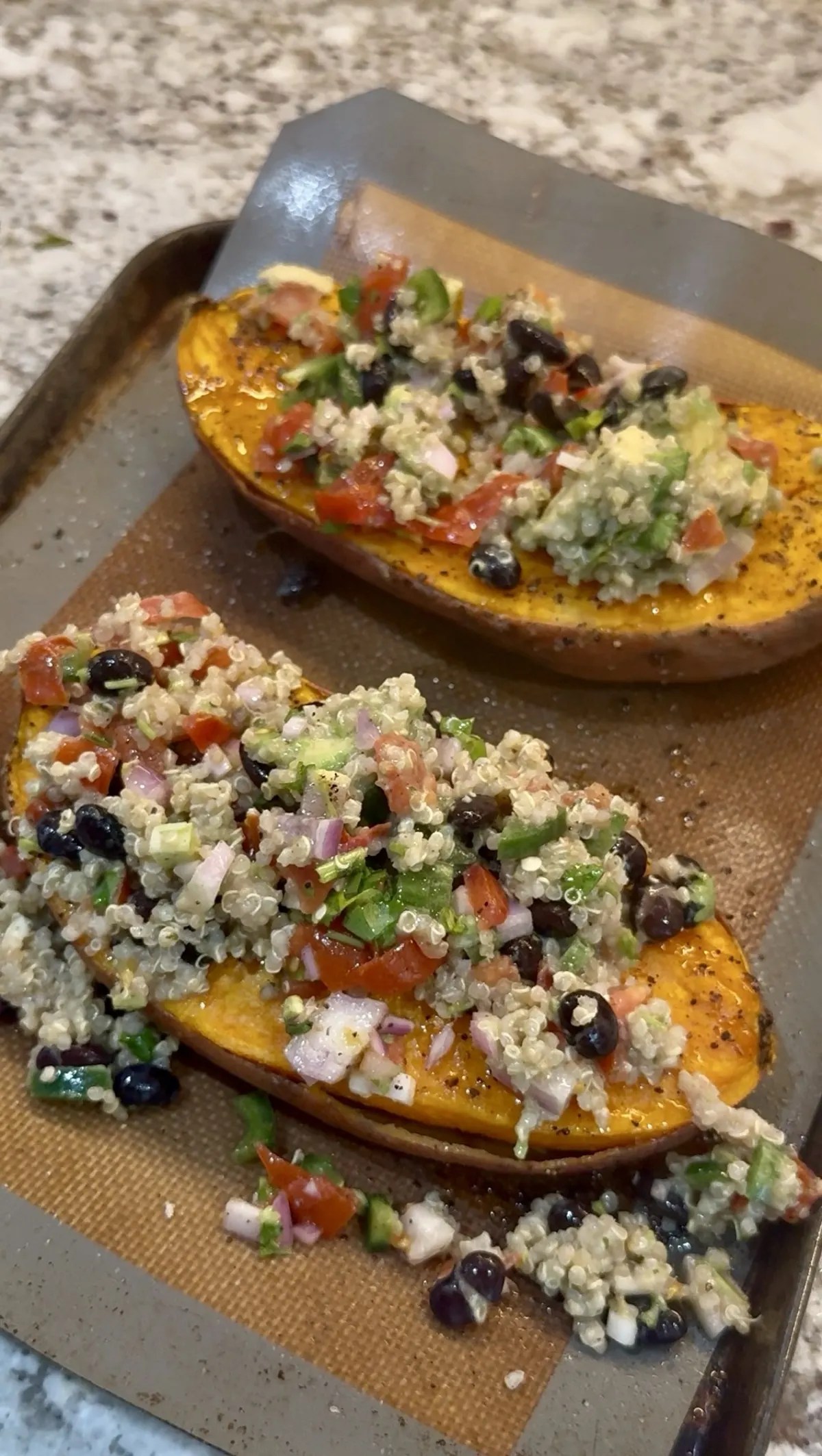Mexican loaded sweet potatoes topped with black beans, corn, fresh tomato salsa, avocado, and a drizzle of lime crema