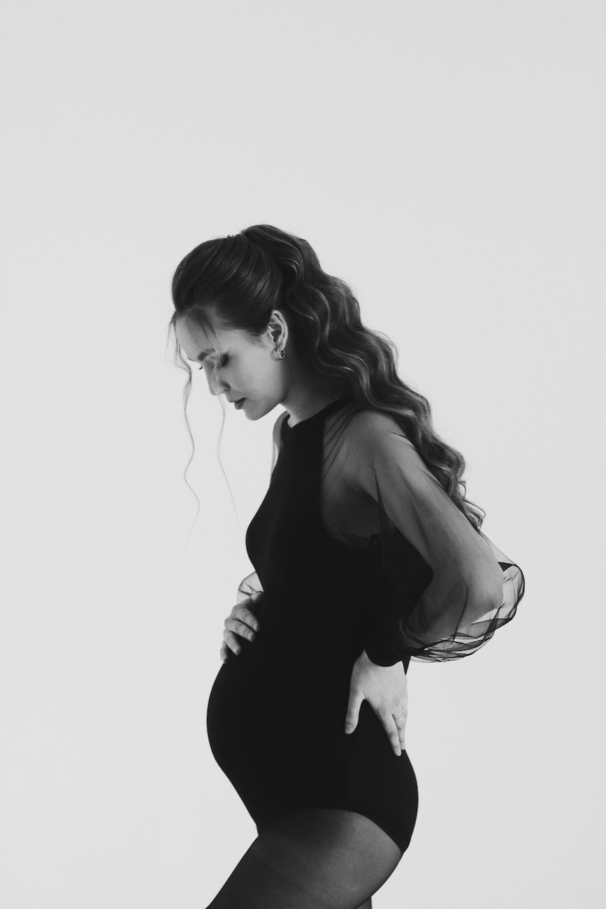 pregnant woman posing and touching her belly
