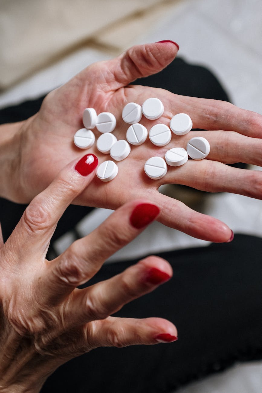 white and orange medication pill on persons hand