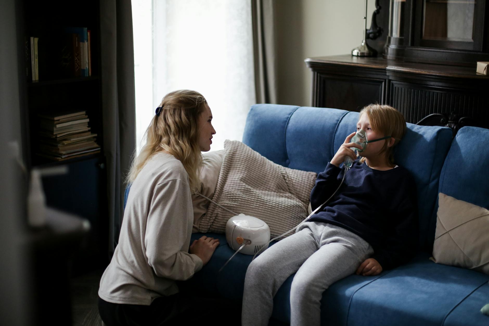 a sick boy in blue long sleeves sitting on the couch