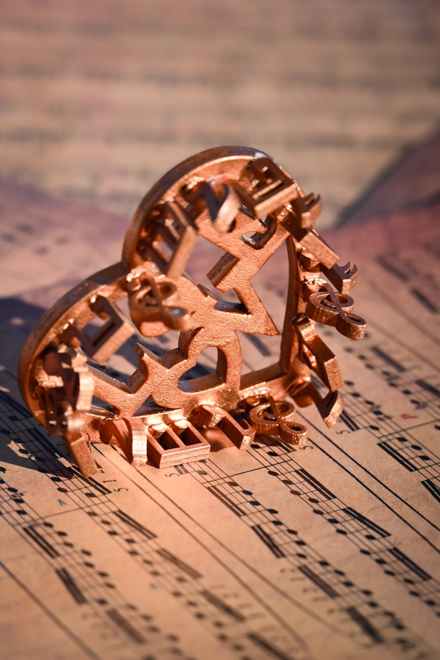 copper heart sculpture on sheet music