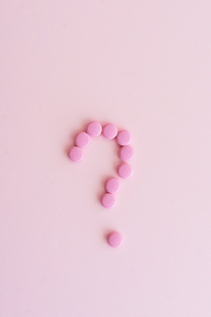 close up shot of pills on pink surface