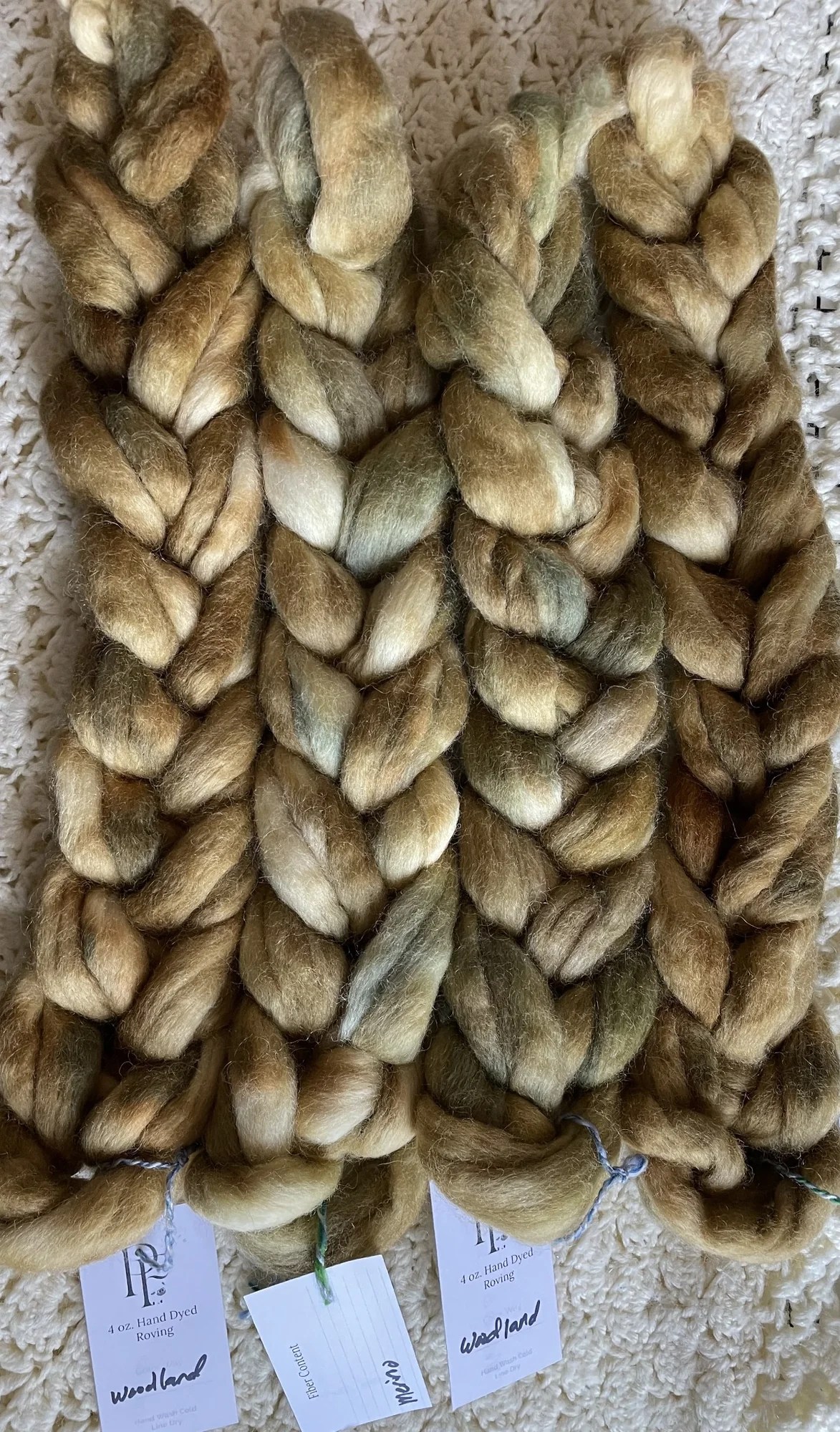 Braids of Australian Merino wool in olive, brown and pale cream tones.