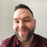 A headshot of Terrell Parker, a white man with a trim beard and short brown hair, wearing a red button up